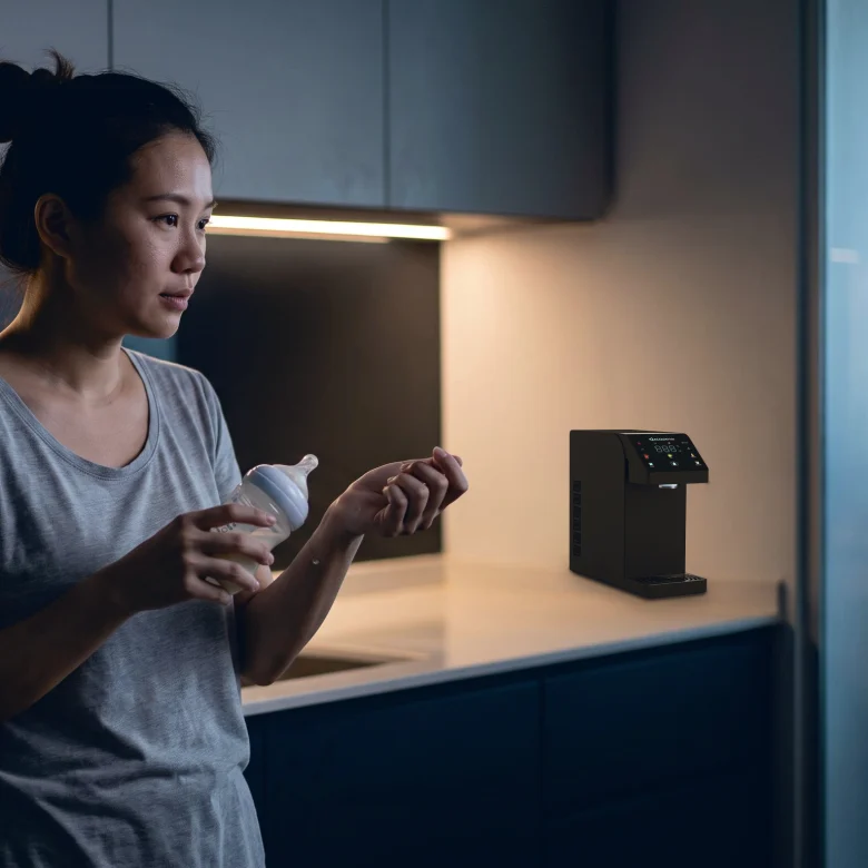 A mother testing warm formula on her wrist at night